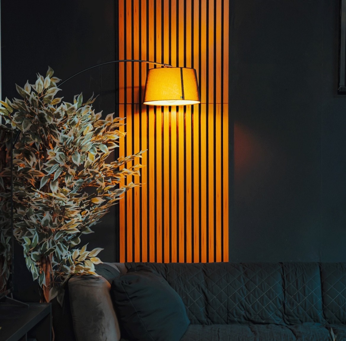 Espace détente du studio avec lampe d'appoint et panneau en lattes de bois
