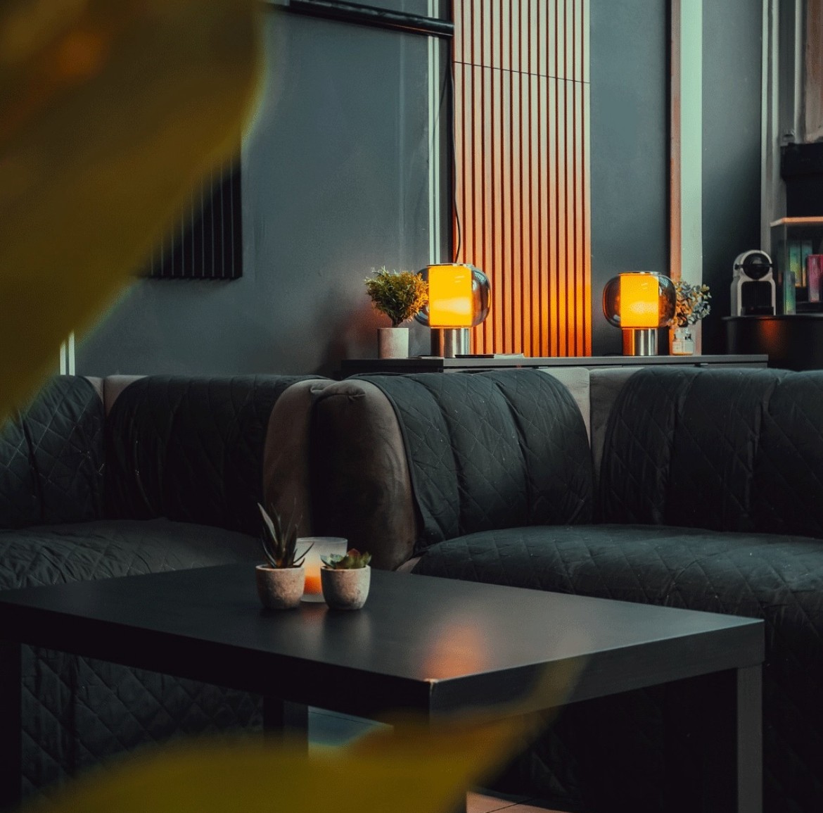 Coin salon du studio avec canapés, table basse et lampes